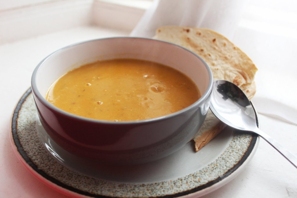 Mixed Potato Soup in a bowl with a spoon and toasted flat bread